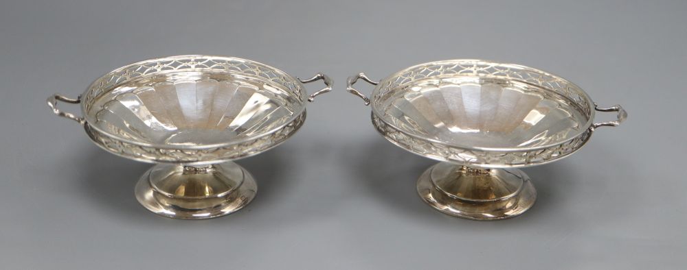 A pair of silver two handled bon bon dishes, with pierced gallery on circular bases, Birmingham 1925, 5.1oz. gross, width 11cm